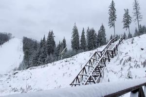 eine Holzbrücke im Schnee auf einem Berg in der Unterkunft Arthotel Mini-Hotel in Bukowel