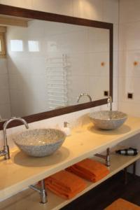 Dois lavatórios numa casa de banho com um espelho grande em BnB Haag em Haag