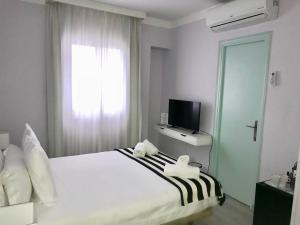 1 dormitorio con 1 cama, TV y ventana en Bluebelle Marbella, en Marbella