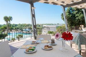 a table with food and a view of the water at Eden Resort Country in Torre San Giovanni Ugento