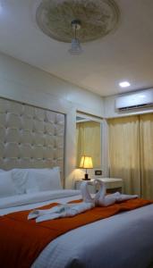 um quarto com uma cama grande com duas bonecas em Setrac Orange em Nova Bombaim