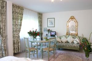 a living room with a table and a couch at Seibel's Park Hotel in Munich