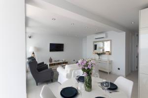 Sala de estar blanca con sofá blanco y mesa en Apartment front line, en Moraira