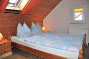 KrumminにあるFerienwohnung Krummin USE 2981のベッドルーム1室(青と紫の枕が備わるベッド1台付)