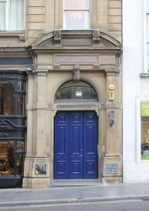 a blue door on the side of a building at The Castle Collection 14 Cook Street in Liverpool