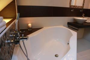 een badkamer met een ligbad en een wastafel bij Penzion Recall in Troskovice
