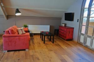 - un salon avec une chaise rouge et une table dans l'établissement Den Dilte, à Jabbeke