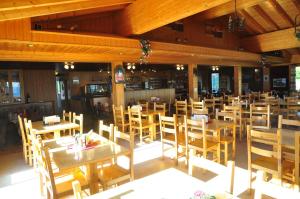 ein leeres Restaurant mit Holztischen und -stühlen in der Unterkunft Appartment Emosson in Finhaut