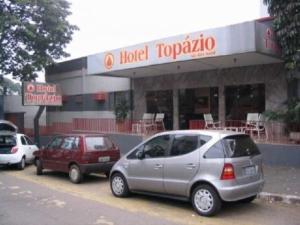 eine Gruppe von Autos, die vor einem Hotel Topkapi geparkt werden in der Unterkunft Hotel Topazio Ltda in Umuarama