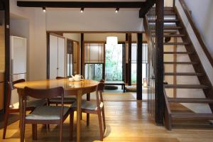 a dining room with a table and a staircase at HANARé Gion in Kyoto