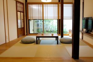 a living room with a table and two pillows at HANARé Gion in Kyoto