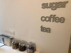a sign that says sugar coffee and tea on a wall at Piano B Apartment in Trento