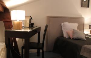 Schlafzimmer mit einem Schreibtisch und einem Bett mit einem sidx sidx sidx in der Unterkunft Résidence et Chambres d'Hôtes de La Porte d'Arras in Douai