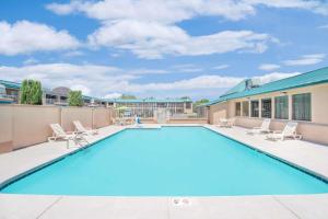 a swimming pool with chairs and a building at Days Inn by Wyndham Roswell in Roswell