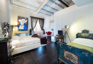 a bedroom with two beds and a television in it at Il Giardino di Ballarò Boutique B&B in Palermo