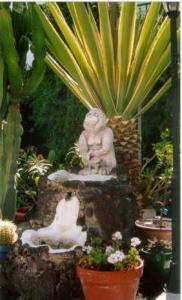 una estatua de un mono sentado en la parte superior de una fuente en San Francisco Park, en Puerto del Carmen