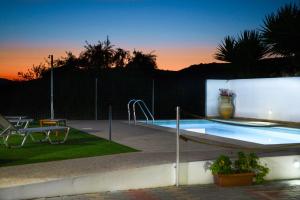 a swimming pool with a sunset in the background at Villa Silvia by Andrian Villas in Kalamítsion Alexándrou