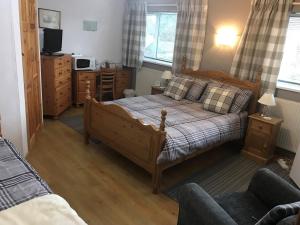 1 dormitorio con 1 cama, TV y sofá en HP Bed and Breakfast, en Congleton