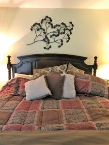 a bedroom with a bed with a tree on the wall at Crescent Arms 105N in Sarasota +17 photos