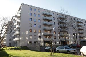 un edificio blanco con coches estacionados frente a él en Lucky-Time pl - 2 pokoje - Ostrów Tumski, en Wroclaw