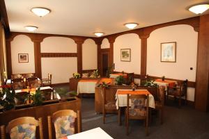 ein Esszimmer mit Tischen, Stühlen und Lampen in der Unterkunft Ackfeld Hotel-Restaurant in Büren