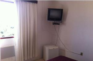 a room with a tv on the corner of a wall at Trevo Parque Hotel in São Sepé