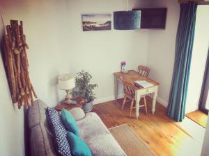 a living room with a couch and a desk at The Side, Gower - Cosy, Coastal, Sea Views & Hot Tub in Horton