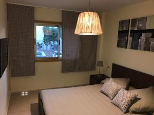 una camera con letto, finestra e lampada di La Perla Medano 2 a El Médano Altre 21 foto