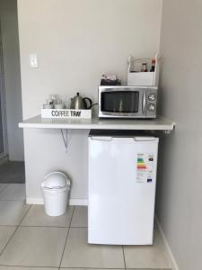 a microwave on top of a refrigerator in a kitchen at 10 on Beresford in East London