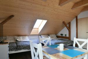 a room with two beds and a table in a attic at Wellness Apartmány Vízmberk in Velké Losiny