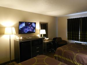 a hotel room with a bed and a desk and a television at Super 8 by Wyndham Fremont NE in Fremont