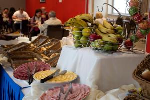 a table topped with baskets of fruit and plates of food at Regency Way Montevideo Hotel in Montevideo