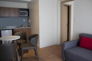 a living room with a couch and a table and chairs at Regency Way Montevideo Hotel in Montevideo