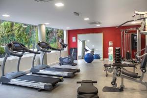 a gym with several treadmills and exercise equipment at Regency Way Montevideo Hotel in Montevideo