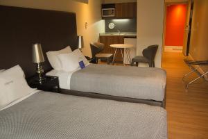a hotel room with two beds and a kitchen at Regency Way Montevideo Hotel in Montevideo