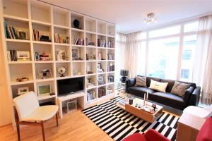 a living room with a couch and a book shelf at GreenKey Apartment - B13 in Reykjavík