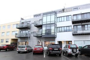 a building with cars parked in a parking lot at GreenKey Apartment - B13 in Reykjavík