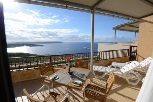a balcony with a table and chairs and the ocean at Il-Bukkett B&B in Qala