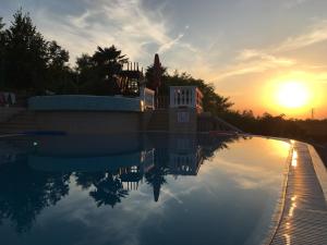 a swimming pool with the sunset in the background at Guest Accommodation Palma in Portorož