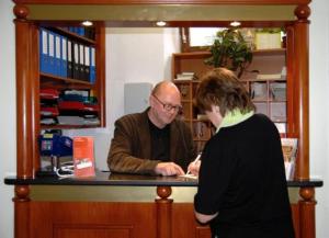 a man and a woman standing at a counter at Suite Hotel 200m zum Prater in Vienna