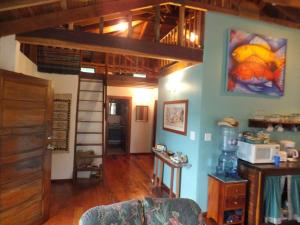 a living room with blue walls and wooden floors at The Bottle Tree House in Caye Caulker