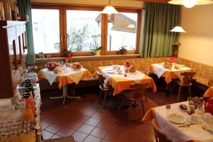 ポスタルにあるGruberhofの黄色いテーブルクロスのテーブル4台付きレストラン