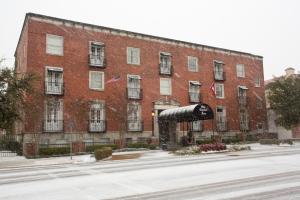 un grand bâtiment en briques rouges en face d'une rue dans l'établissement Old Capitol Inn, à Jackson