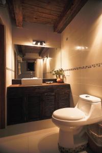 a bathroom with a white toilet and a sink at Hotel La Casa de Maty in Tapalpa