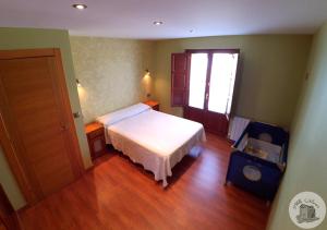 コロンブレスにあるCasa Rural Villa Auroraのウッドフロアのベッドルーム1室(白いベッド1台付)
