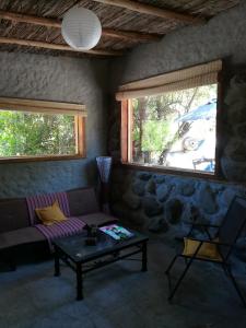 sala de estar con sofá y mesa en El Cielo Lodge, en San José de Maipo