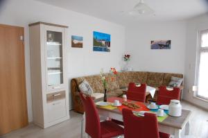 a living room with a table and red chairs at Ferienwohnung Prey in Ueckermünde