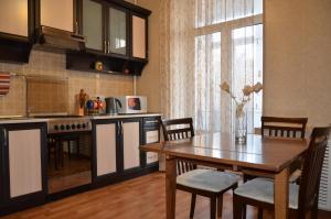 a kitchen with a wooden table and a dining room at Apartments in the city centre of Nikolaev in Mykolaiv