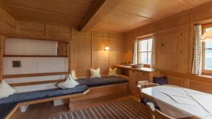 ein Schlafzimmer mit zwei Betten in einem Holzzimmer in der Unterkunft Aussermooserhof in Alpbach