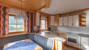 eine Küche mit weißen Schränken und einer blauen Arbeitsplatte in der Unterkunft Aussermooserhof in Alpbach